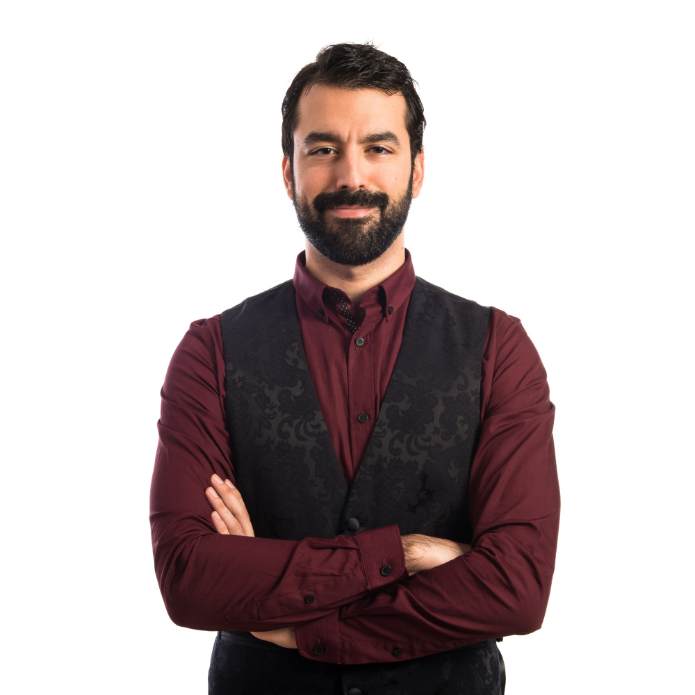 Person in red shirt and black vest with arms crossed.
