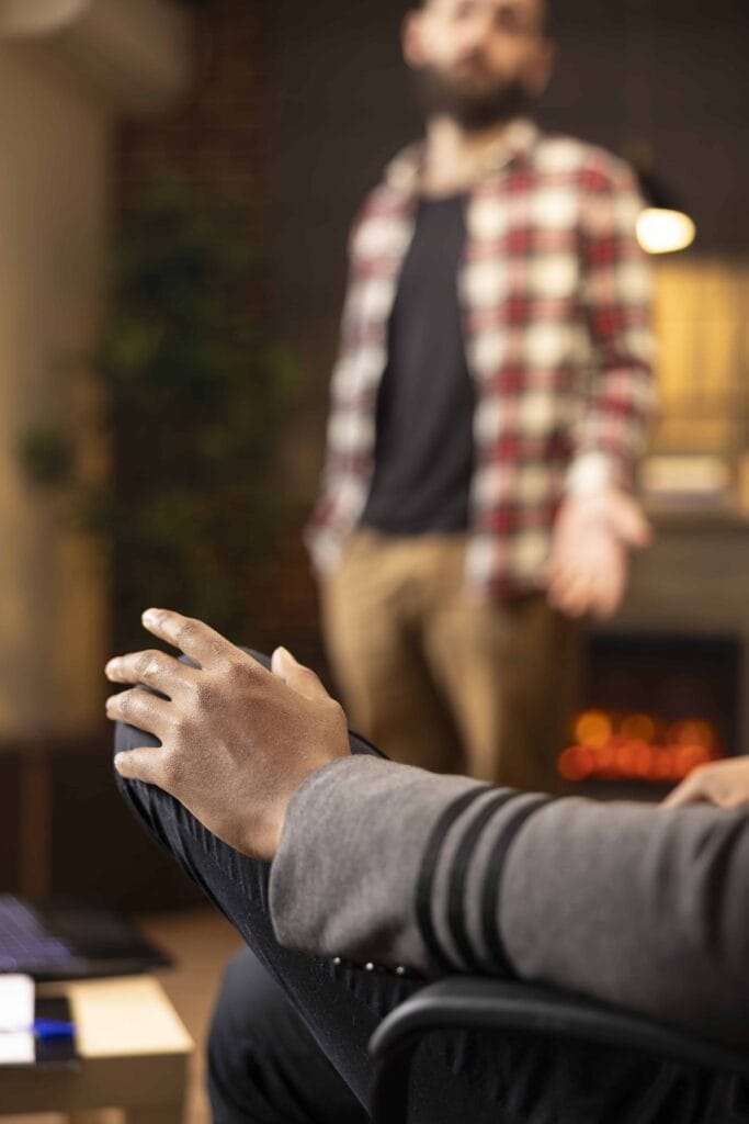 man in the background speaking with specialist on is massachusetts rehab covered by insurance